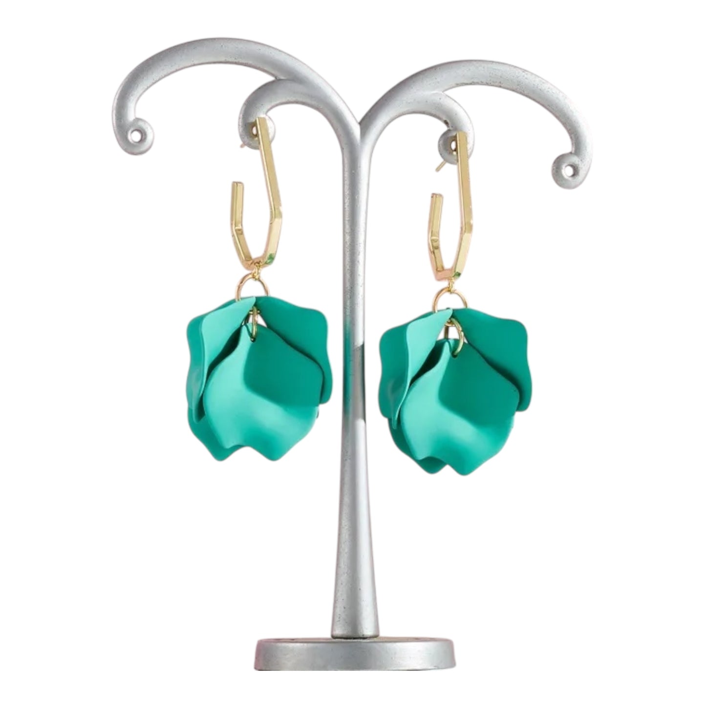 Turquoise earrings on a silver earring stand against a white background