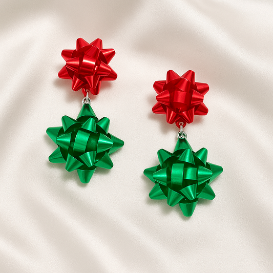 Pair of earrings with red and green bow designs on a beige background
