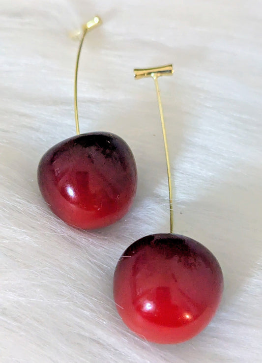 Pair of red cherry-shaped earrings on a white background