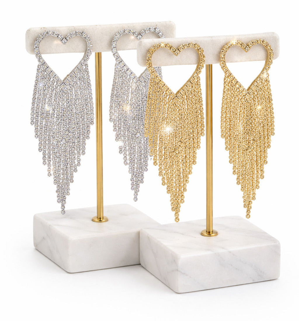 Pair of tassel earrings on a white marble stand with gold and silver options.