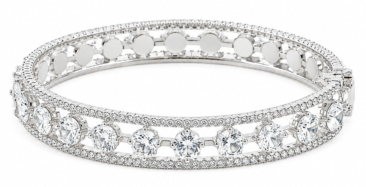 A silver-toned hinged bangle bracelet adorned with clear round-cut and round pavé gemstones, shown against a plain white background.
