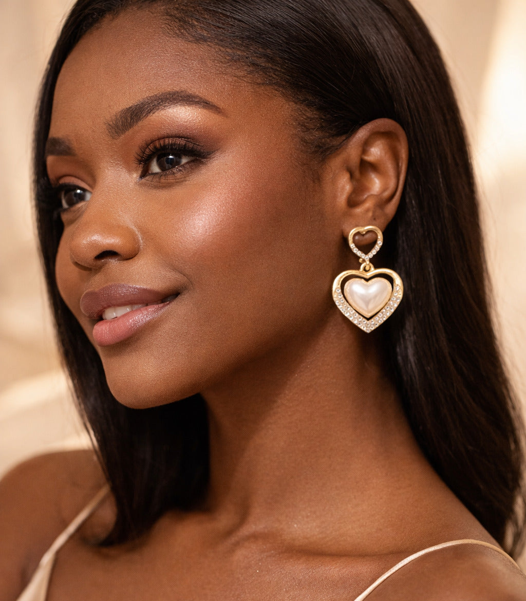 Woman wearing heart-shaped earrings with a neutral background