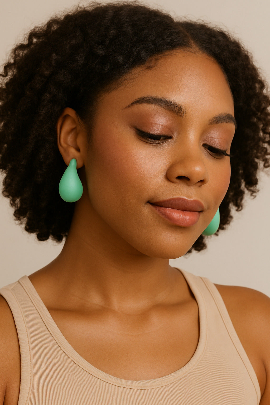 Woman wearing turquoise earrings against a neutral background