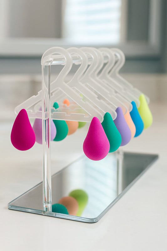 Colorful teardrop-shaped objects on clear hangers with a mirror background