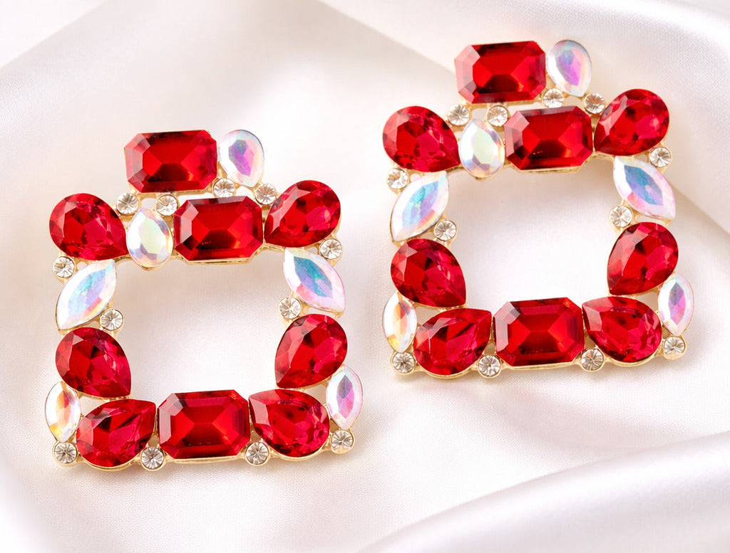 Red gemstone earrings on a white satin background