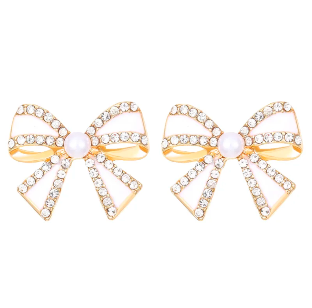 Gold bow-shaped earrings with pearl centers on a white background