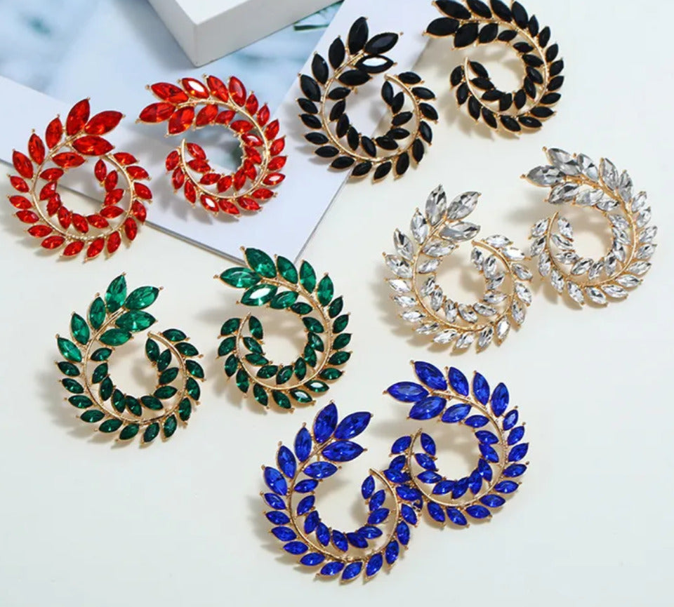 Colorful wreath-shaped earrings on a white surface