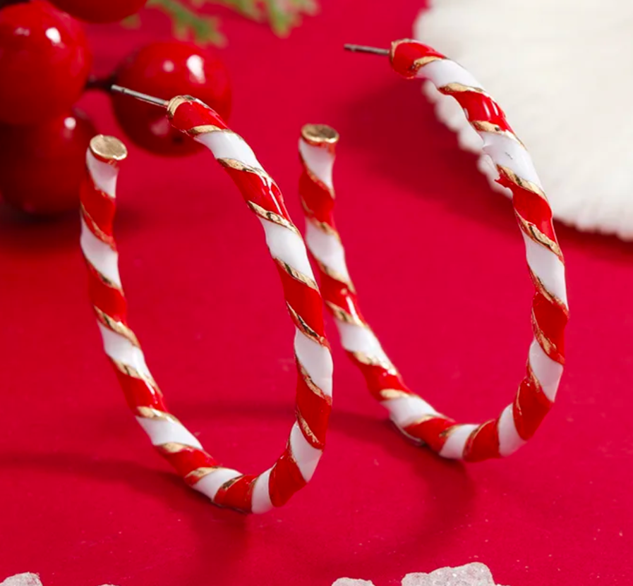 Red and white striped hoop earrings on a red background with cherries and Santa hat.