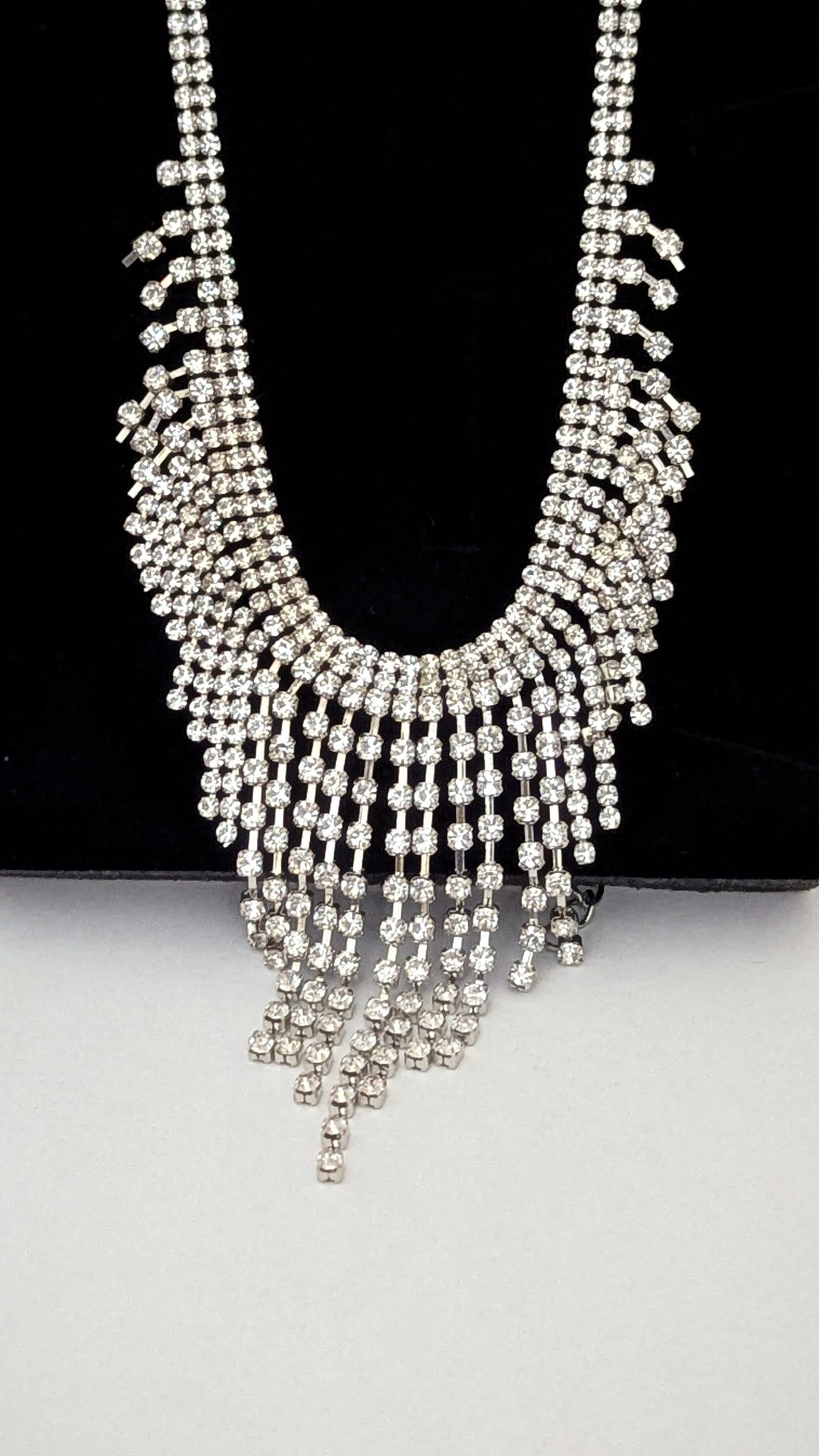 Silver beaded necklace on a black and white background