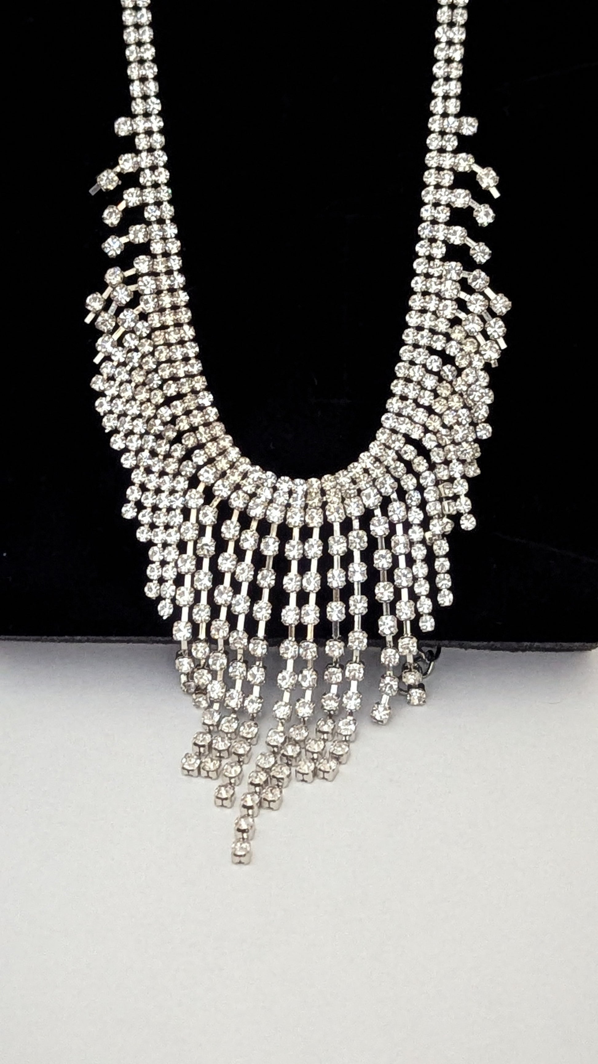 Silver beaded necklace on a black and white background