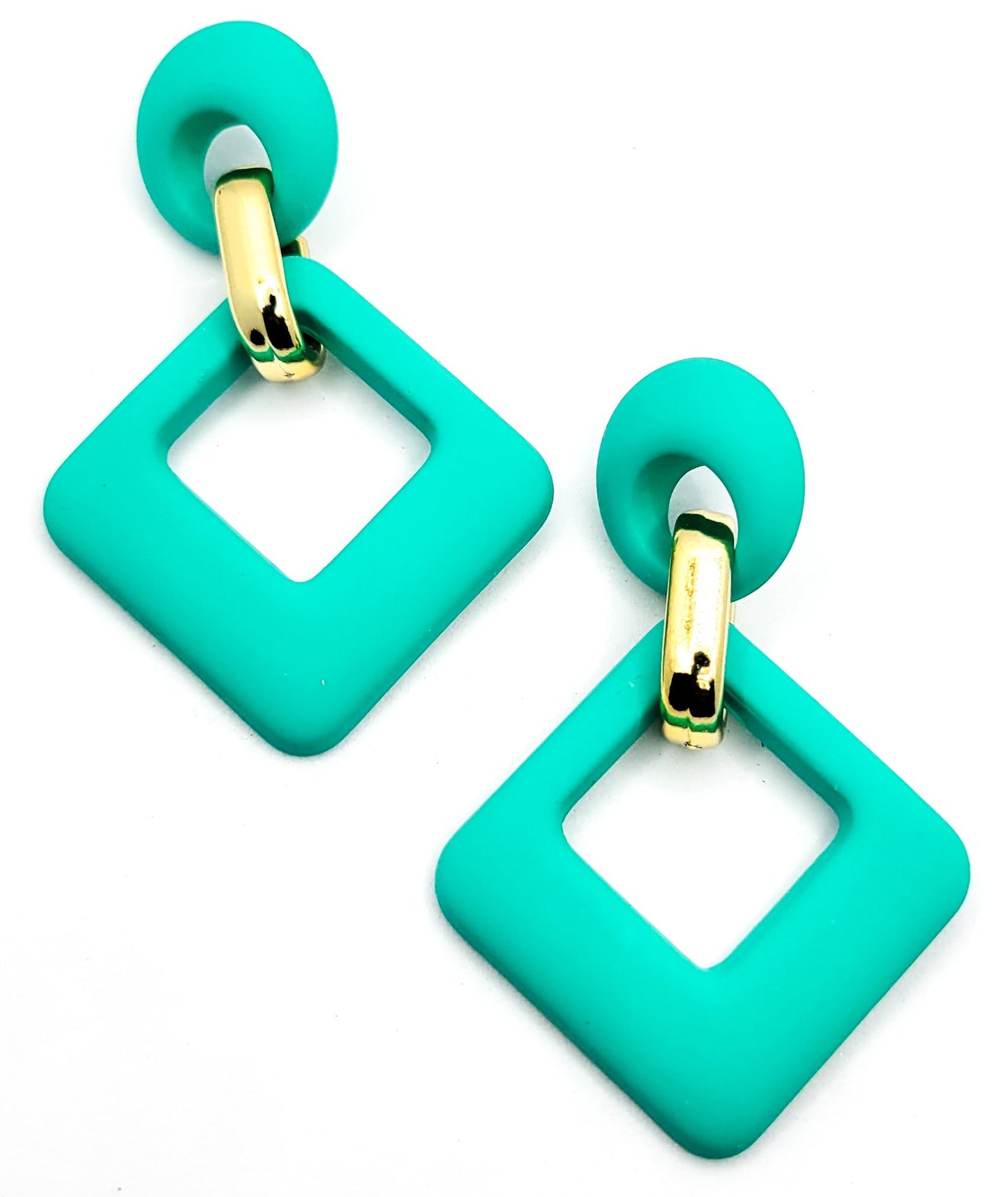 A person wearing the velvet rhombus drop earrings with a gold clip attachment, showcasing the earrings in an orange and black color.