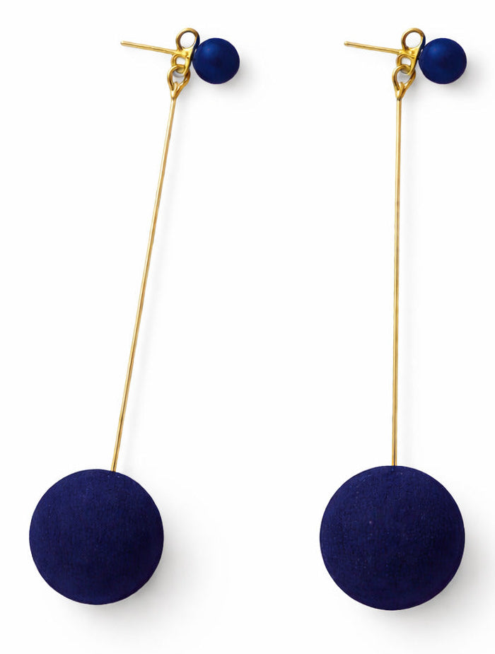 Pair of earrings with navy blue spherical pendants on gold hooks against a white background
